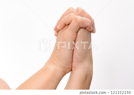 Close-up of clasped hands against a white background. 121312150