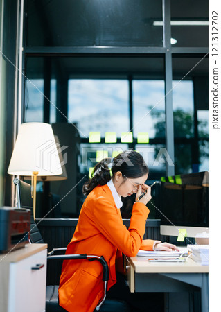 Asian woman feeling migraine head strain.Overworked businesswoman financier while working Asian woman feeling migraine head strain.Overworked businesswoman financier while working 121312702