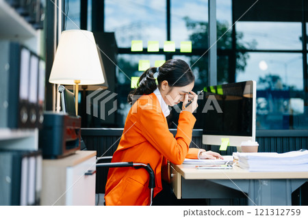 Asian woman feeling migraine head strain.Overworked businesswoman financier while working 121312759