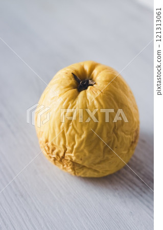 Rotten apple on white background. Yellow wrinkled apple. Aging process concept. Skin care concept. Decay in nature. Passing of time concept. Rotten apple on white background. Yellow wrinkled apple. Aging process concept. Skin care concept. Decay in nature. Passing of time concept. 121313061