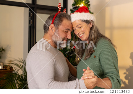Dancing joyfully at home, mature couple celebrating Christmas together 121313483