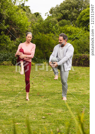 Mature couple practicing yoga together outdoors, enjoying peaceful morning exercise Mature couple practicing yoga together outdoors, enjoying peaceful morning exercise 121313497