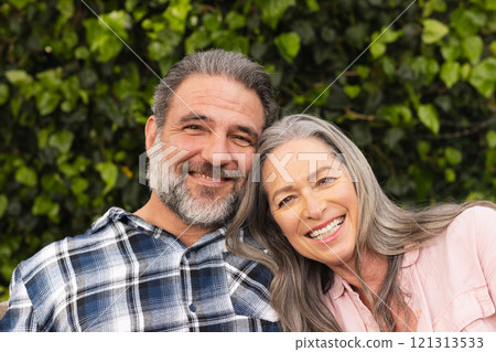 Smiling mature couple enjoying time together outdoors in lush green garden Smiling mature couple enjoying time together outdoors in lush green garden 121313533