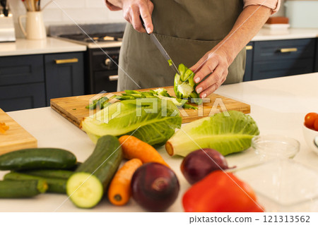 Preparing fresh vegetables in kitchen, mature woman chopping green pepper, at home 121313562