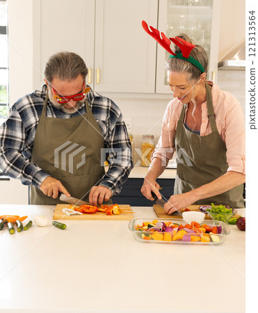 Christmas time, mature couple preparing vegetables in kitchen, at home 121313564
