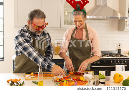 Christmas time, mature couple preparing festive meal in kitchen, at home 121313570