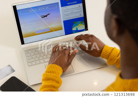 Booking holiday travel online, African american man using laptop at home, planning vacation Booking holiday travel online, African american man using laptop at home, planning vacation 121313698