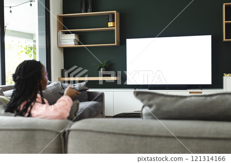 African american woman watching tv with copy space, slow motion 121314166