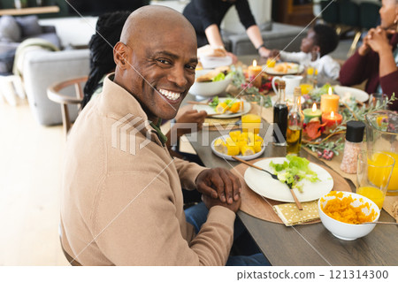 Portrait of african american father with family smiling at thanksgiving dinner table 121314300