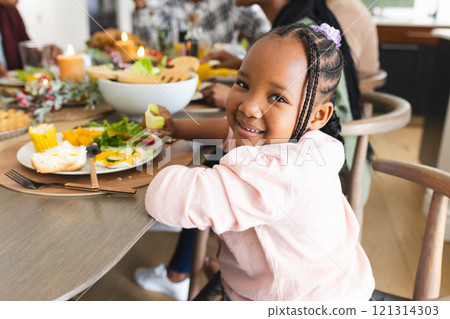 Portrait of african american daughter smiling at thanksgiving dinner table 121314303