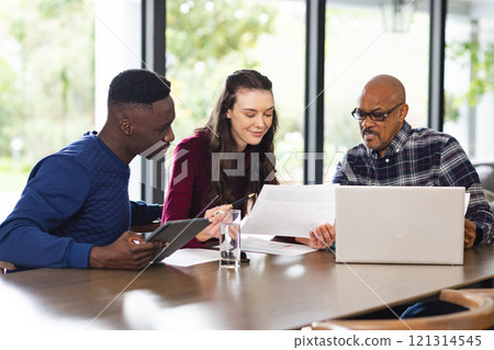 Diverse couple and biracial male financial advisor using laptop and discussing documents at home Diverse couple and biracial male financial advisor using laptop and discussing documents at home 121314545