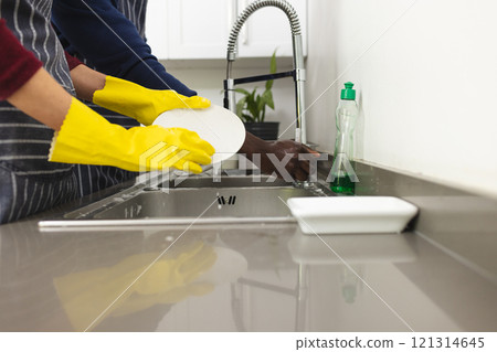 Midsection of diverse couple doing dishes in kitchen at home Midsection of diverse couple doing dishes in kitchen at home 121314645
