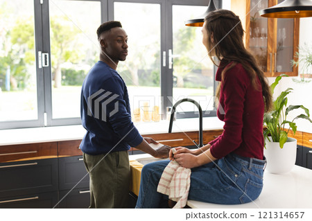 Happy diverse couple doing dishes in kitchen at home 121314657