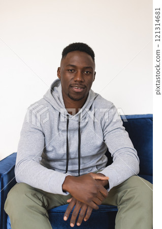 Happy african american man sitting in armchair having video call at home Happy african american man sitting in armchair having video call at home 121314681