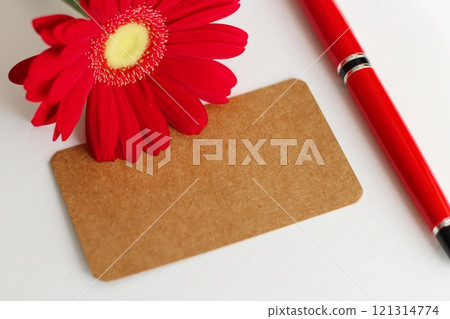 棕色留言卡、紅色非洲菊和紅色鋼筆 棕色留言卡、紅色非洲菊和紅色鋼筆 121314774