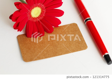 棕色留言卡、紅色非洲菊和紅色鋼筆 棕色留言卡、紅色非洲菊和紅色鋼筆 121314775