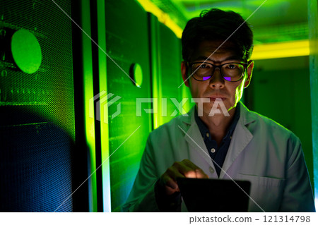 Portrait of asian male engineer wearing an apron using digital tablet in computer server room Portrait of asian male engineer wearing an apron using digital tablet in computer server room 121314798