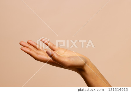 Outstretched hand of biracial woman on pink beige background with copy space 121314913