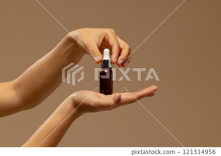 Hand of asian woman holding dropper bottle of skin tonic with copy space 121314956