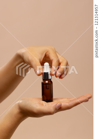 Vertical of hands of asian woman holding dropper bottle of skin tonic with copy space Vertical of hands of asian woman holding dropper bottle of skin tonic with copy space 121314957