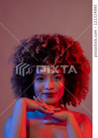 Smiling biracial woman wearing pink eyeshadow and lipstick in blue and red light, copy space Smiling biracial woman wearing pink eyeshadow and lipstick in blue and red light, copy space 121314995