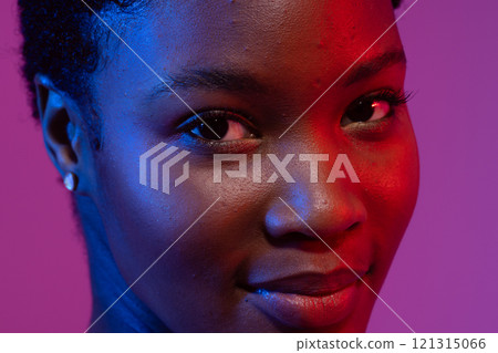 Close up of smiling african american woman with short hair in blue and red light Close up of smiling african american woman with short hair in blue and red light 121315066