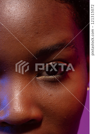 Close up of eye and nose of african american woman on purple background 121315072