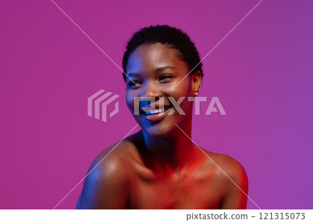 African American woman with short hair smiles away in blue, red light, purple backdrop African American woman with short hair smiles away in blue, red light, purple backdrop 121315073
