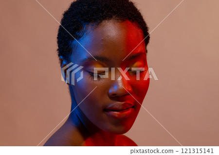 African american woman with short hair and eyes closed in blue and red light African american woman with short hair and eyes closed in blue and red light 121315141