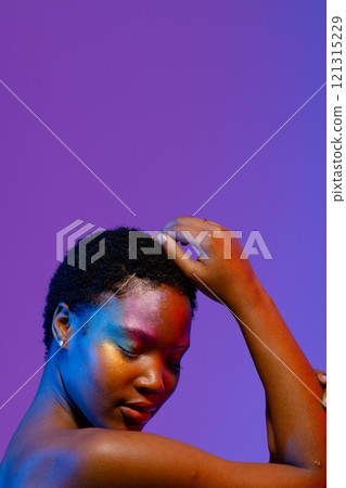 African american woman with short hair and colourful make up touching head, eyes closed, copy space 121315229