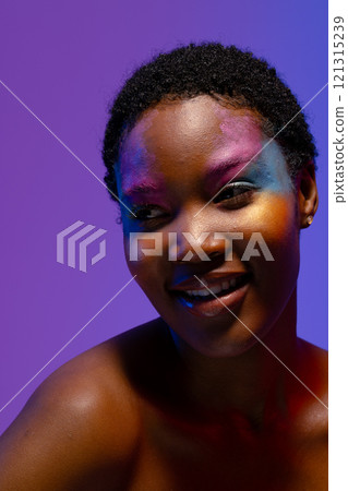Smiling african american woman with short hair and colourful makeup looking away Smiling african american woman with short hair and colourful makeup looking away 121315239