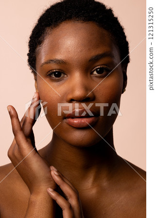 Vertical of african american woman with short hair touching hands and face Vertical of african american woman with short hair touching hands and face 121315250