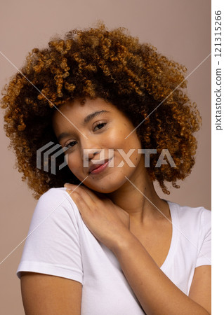 Biracial woman with curly hair, smiling with hand on shoulder 121315266