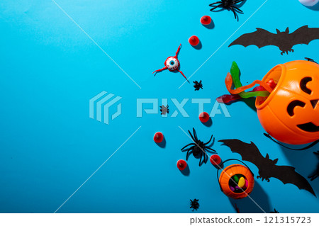 Close up view of multiple halloween candies and toys against blue background Close up view of multiple halloween candies and toys against blue background 121315723