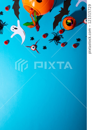 Close up view of multiple halloween candies and toys against blue background Close up view of multiple halloween candies and toys against blue background 121315729