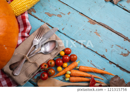 Close up of multiple food ingredients and cutlery with copy space on blue wooden surface 121315756