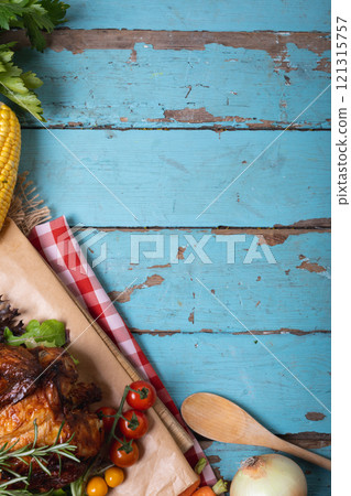 Close up of multiple food ingredients and cutlery with copy space on blue wooden surface 121315757