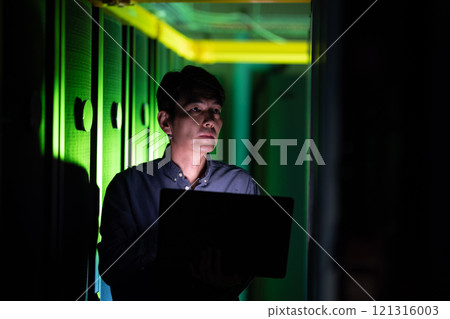 Asian male engineer using laptop while inspecting in computer server room Asian male engineer using laptop while inspecting in computer server room 121316003