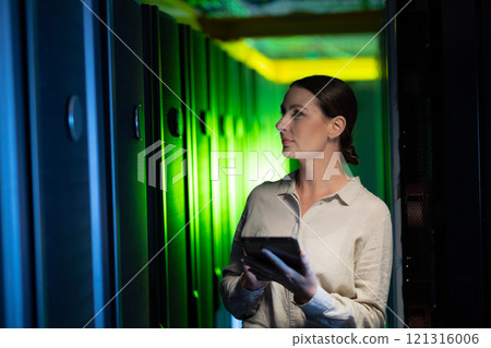 Caucasian female engineer using digital tablet while inspecting in computer server room Caucasian female engineer using digital tablet while inspecting in computer server room 121316006