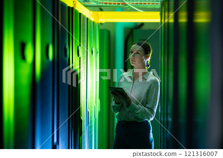 Caucasian female engineer using digital tablet while inspecting in computer server room Caucasian female engineer using digital tablet while inspecting in computer server room 121316007