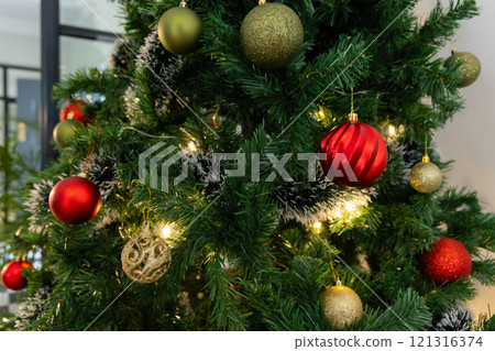 Festive Christmas tree decorated with colorful ornaments and glowing lights, at home Festive Christmas tree decorated with colorful ornaments and glowing lights, at home 121316374