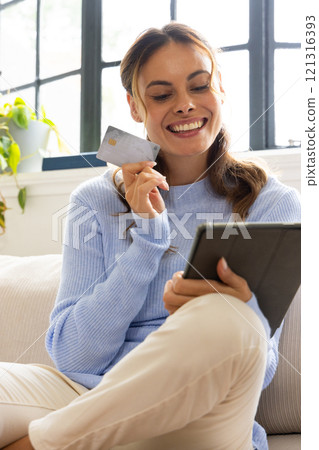 Smiling woman shopping online with tablet and credit card at home Smiling woman shopping online with tablet and credit card at home 121316393