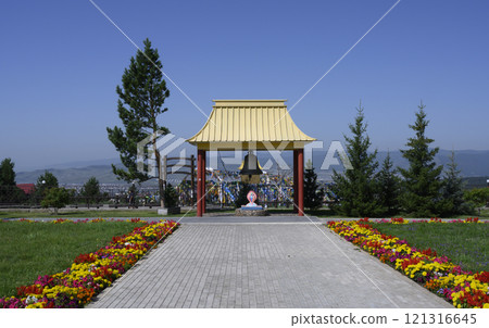 Buddhist architecture building of Datsane Rinpoche Bagsha, canopy with bell and lawn with flowers 121316645