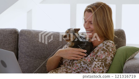 Woman playing with her dog in living room at home 4k 121316719
