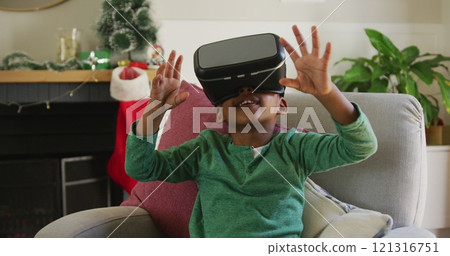 Happy african american boy wearing vr headset and having fun at christmas time Happy african american boy wearing vr headset and having fun at christmas time 121316751