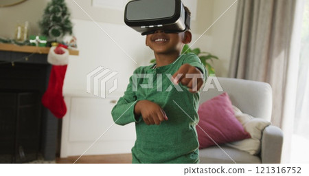 Happy african american boy wearing vr headset and having fun at christmas time 121316752