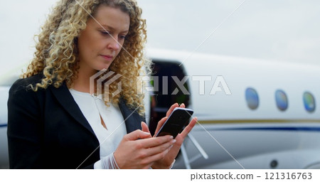 Beautiful businesswoman using mobile phone at terminal 4k 121316763