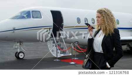 Beautiful businesswoman talking on mobile phone at terminal 4k 121316768