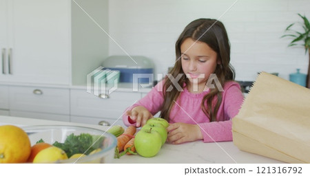 Happy caucasian girl unpacking groceries in kitchen Happy caucasian girl unpacking groceries in kitchen 121316792