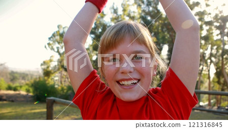 Happy girl cheering in boot camp during obstacle course 121316845